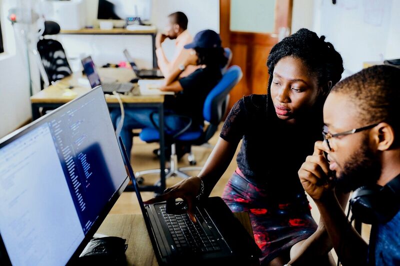 Zenith Glow Inc. team members collaborating and mentoring at a workstation